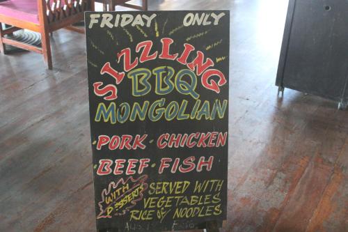 a chalkboard sign that says happy bbq mongolian pork chicken at Club Fiji Resort in Nadi