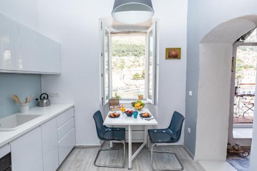 een keuken met een kleine witte tafel en stoelen bij Apartment CATIVLA in Dubrovnik