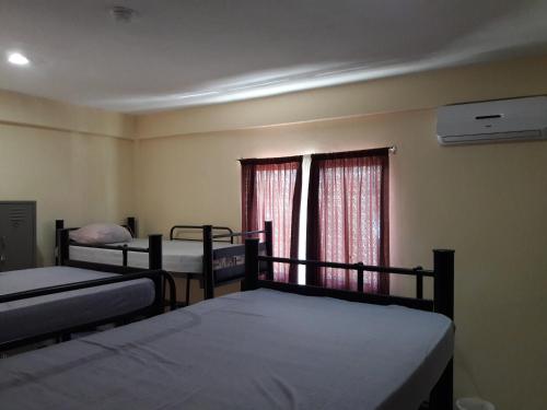 プラヤ・デル・カルメンにあるAlme Hostel Centro Playa del Carmenのベッドが3つと窓のある部屋
