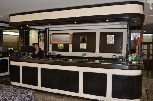 a woman sitting at a bar in a lobby at Hotel Oicatá in Duitama