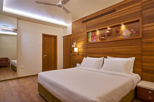 a bedroom with a large bed with a wooden wall at Hotel Atharv Top Rated Business Hotel in Kolhapur in Kolhapur