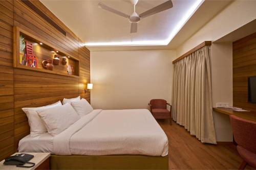 a hotel room with a bed and a ceiling fan at Hotel Atharv Top Rated Business Hotel in Kolhapur in Kolhapur