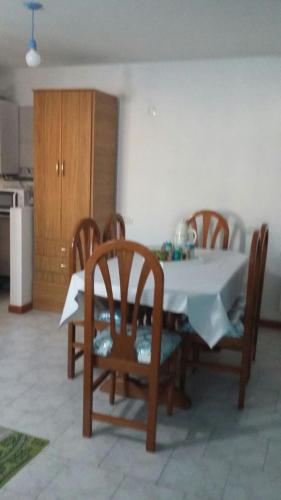 mesa de comedor con sillas y mantel blanco en Departamento de Celina en Olavarría