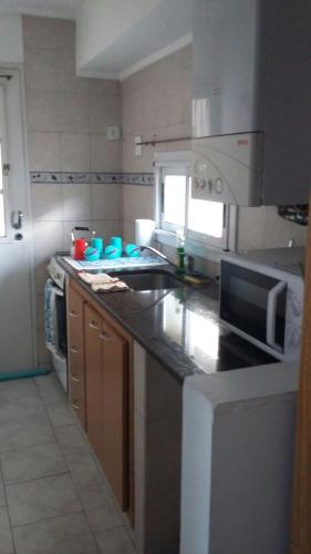 cocina con fregadero y fogones horno superior en Departamento de Celina en Olavarría