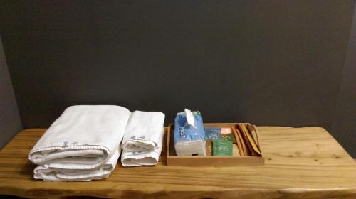 台東市的住宿－魔法奶油飛民宿，一张带毛巾的木桌和盒子