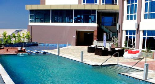 a swimming pool in front of a building at Meritz Hotel in Miri
