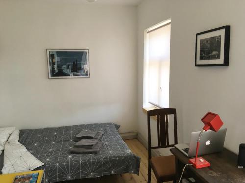 a small bedroom with a bed and a window at Vintage Design Apartment in Kuldīga