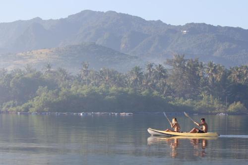 two people on a paddle boat in the water at Sumberkima Hill Retreat in Pemuteran