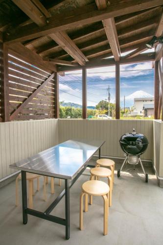 a patio with a table and chairs and a grill at Villa Yushin in Fujikawaguchiko