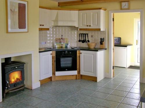 a kitchen with a stove in the middle of it at Lough Currane Cottage in Waterville