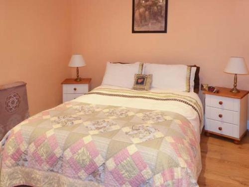 a bedroom with a bed with two night stands and two lamps at The Lake House, Connemara in Knock