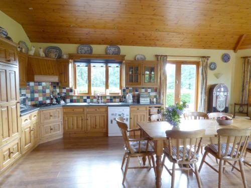 a kitchen with wooden cabinets and a table and chairs at Maifield in Mullennaglogh