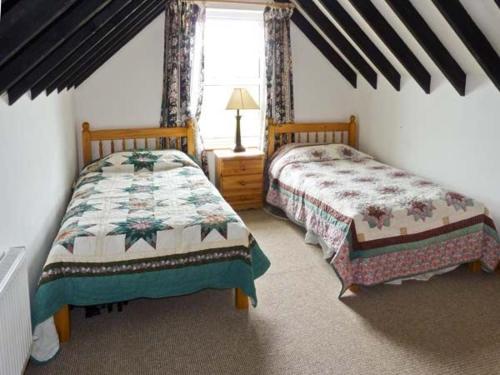 - une chambre avec 2 lits et une fenêtre dans l'établissement Lully More Cottage, à Doochary