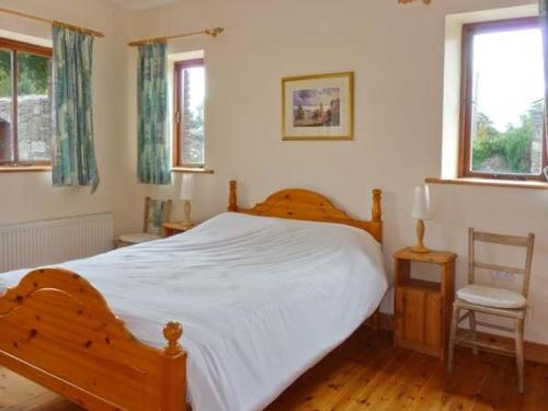 1 dormitorio con 1 cama blanca grande y 1 silla en The Range, en Enniscorthy
