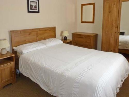 a bedroom with a large white bed and two night stands at Burke Cottage in Lismore