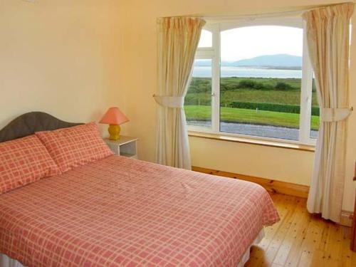 a bedroom with a bed and a large window at Heron's Nest in Inch