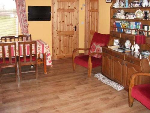 a living room with a table and chairs and a table at Hazel Cottage in Kilmore