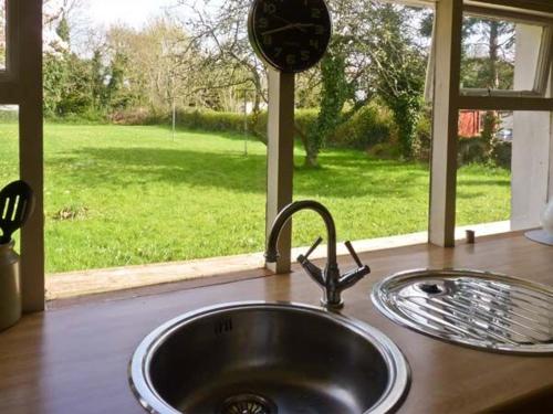 a kitchen sink with a view of a yard at Burke Cottage in Lismore