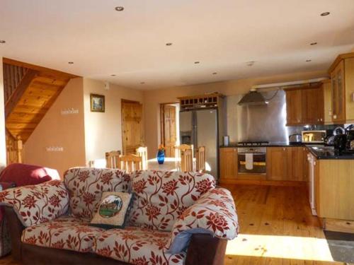 uma sala de estar com um sofá e uma cozinha em Corr an Droma em Rossbrin