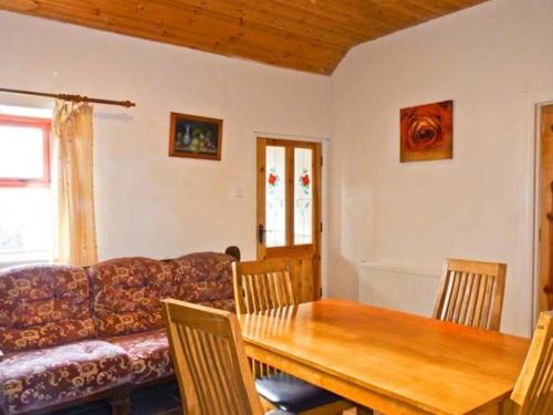 een woonkamer met een tafel en een bank bij Cavan Hill Cottage in Ballinrobe