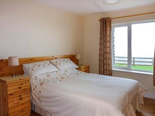 a bedroom with a large bed and a window at Kerry Way Cottage in Coad