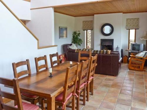 un soggiorno con tavolo e sedie in legno di Finn House a Castlegregory