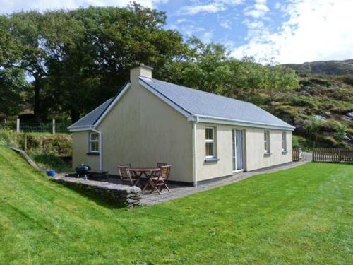 a small house with a picnic table in a yard at The Bay in Caherdaniel