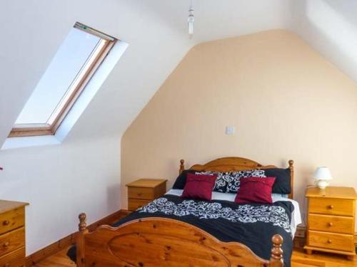 a bedroom with a wooden bed and a window at Corr an Droma in Rossbrin
