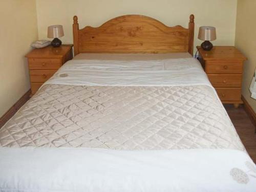 a bedroom with a white bed with two night stands at Hazel Cottage in Kilmore