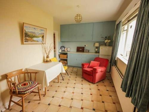 a kitchen with a table and a red chair at Teach Annie in Falcarragh