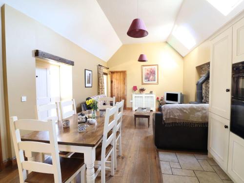 een eetkamer en een woonkamer met een tafel en stoelen bij Rosemount Coach House in Ballycarney