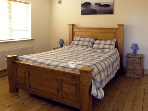 a bedroom with a wooden bed with two night stands at 19 River Glen in Curracloe