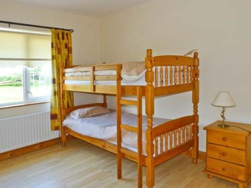 a bedroom with two bunk beds and a table at Sallywood House in Corraffrin