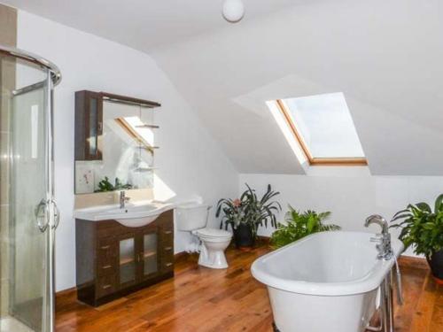 uma casa de banho com uma banheira, um WC e um lavatório. em Waters House em Bannow