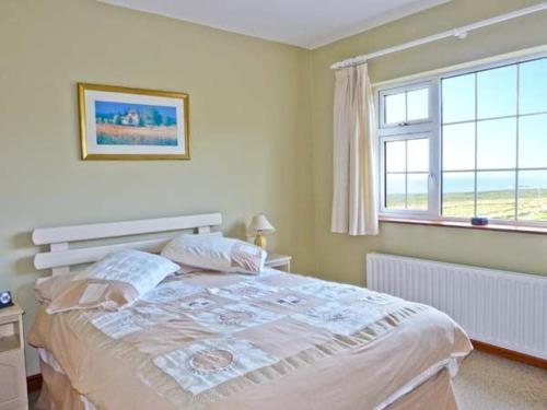 a bedroom with a large bed and a window at Carraig Oisin in Waterville