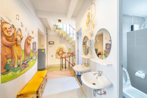 een badkamer met 2 wastafels en een trap bij Sloth Hostel Khaosan in Bangkok