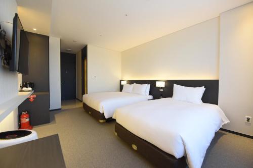 Кровать или кровати в номере Geoje Artnouveau Suite Hotel