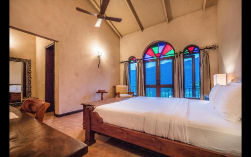a bedroom with a bed and two stained glass windows at The Orchard at Peora Estates in Mukteswar