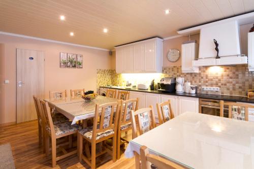 a kitchen and dining room with a table and chairs at Janza Apartman in Bük