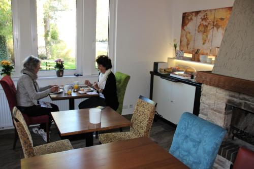 two women sitting at tables in a restaurant at Haus im Donautal in Beuron