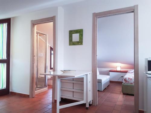 una habitación con una mesa y una cama y un espejo en Mansarda con Vista Piscina, en Campofelice di Roccella