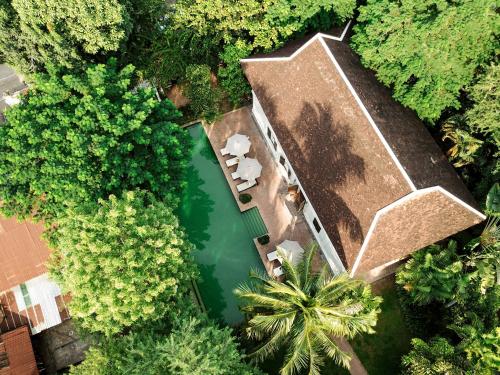 an aerial view of a house with a pool in a forest at Satri House Hotel in Luang Prabang