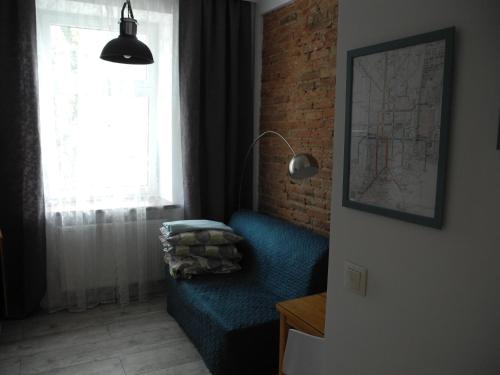sala de estar con sofá azul y ventana en Apartament N°10, en Łódź