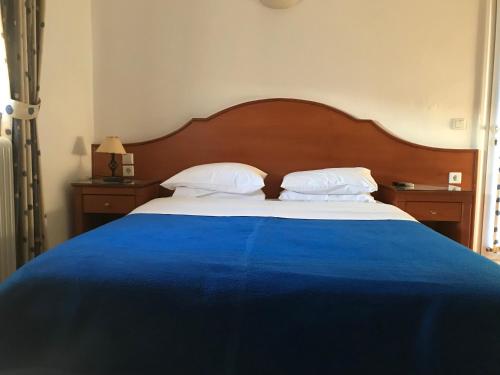a bed with a blue blanket and white pillows at Agnanti in Ávdhira