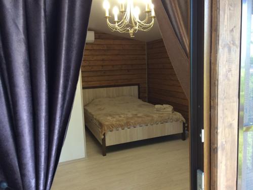 - une chambre avec un lit et un lustre dans l'établissement Pican, à Goudaouta
