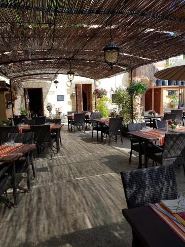 un restaurant avec des tables et des chaises en bois et un chercheur de table dans l'établissement Le Relais Des Dentelles, à Beaumes-de-Venise
