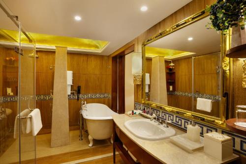 a bathroom with a tub and a sink and a mirror at The Grand Dragon Ladakh in Leh