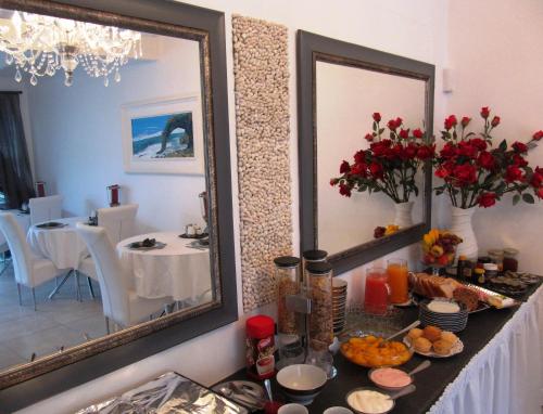 a table with food and a mirror in a room at Pebble Stone House Bed & Breakfast in Swakopmund