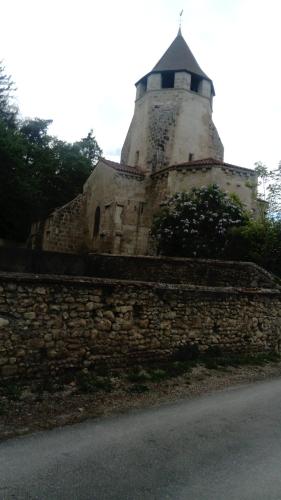 a stone wall with a tower on top of it at Gite de Marcureau in Louchy-Montfand