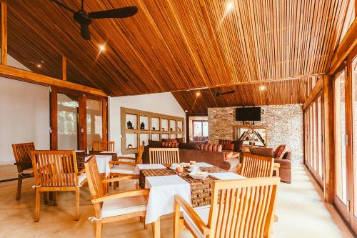 a living room with wooden ceilings and a table and chairs at Hemingways Retreat Kigali in Kigali